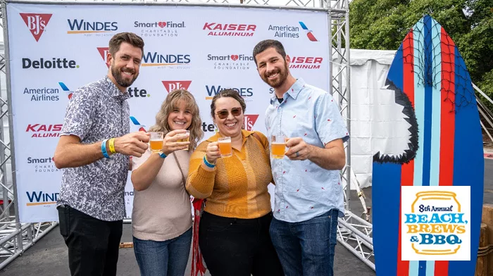 4 people posing at Beach, Brews & BBQ event